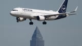 ’n Lufthansa-passasiersvliegtuig land by Frankfurt-lughawe Die vliegtuig vlieg oor die Messeturm. Die lugdiens bied Woensdag sy kwartaalsyfers aan. 